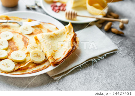 Tasty beautiful pancakes with banana and honey Tasty beautiful pancakes with banana and honey 54427451