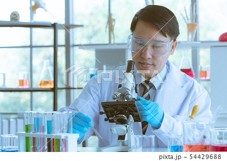 Scientist adjusting microscope for experiment. Scientist adjusting microscope for experiment. 54429688