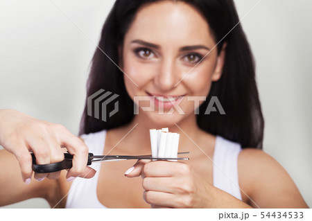 Quit Smoking. Closeup Of Female Hands Holding A Bunch Of Cigarettes And Cutting Them In Halves With Quit Smoking. Closeup Of Female Hands Holding A Bunch Of Cigarettes And Cutting Them In Halves With 54434533