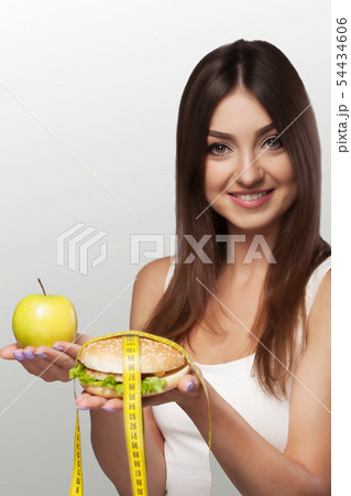 Hands offer an apple healthy food and cakes unhealthy food to each other. The concept of choice Hands offer an apple healthy food and cakes unhealthy food to each other. The concept of choice 54434606
