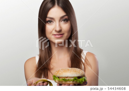 Hands offer an apple healthy food and cakes unhealthy food to each other. The concept of choice Hands offer an apple healthy food and cakes unhealthy food to each other. The concept of choice 54434608