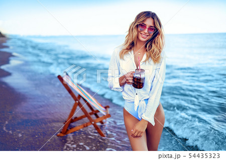 Pretty woman relaxing on beach and drinks coctail. summer vacation concept 54435323