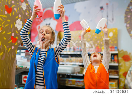 Girls in uniform playing with shampoo, playroom 54436682