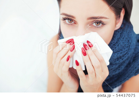 Woman Suffering From Cold Lying In Bed With Tissue 54437075