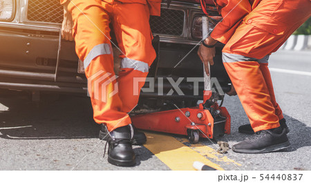 Rescue helping put emergency jack in broken car on 54440837