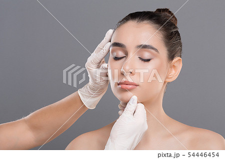 Young woman on consultation at beautician, grey background 54446454