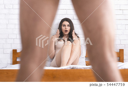 Woman in disbelief looking what's between man's legs 54447759