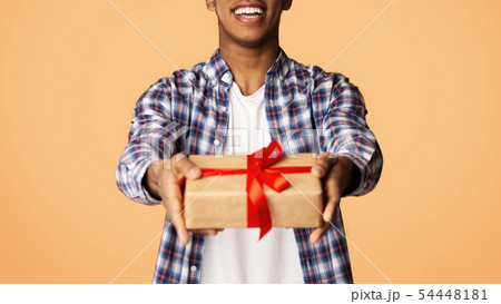 Cheerful Guy Offering Exclusive Gift Box to Camera Cheerful Guy Offering Exclusive Gift Box to Camera 54448181