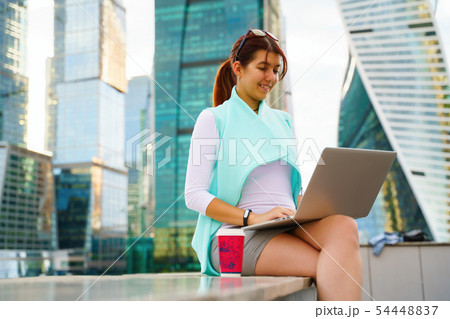 Portrait of business woman sitting with laptop and cup of coffee 54448837
