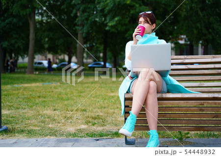 Portrait of business woman sitting with laptop and cup of coffee 54448932