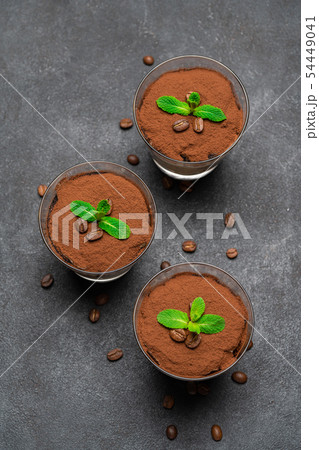 Classic tiramisu dessert in a glass on dark concrete background Classic tiramisu dessert in a glass on dark concrete background 54449041