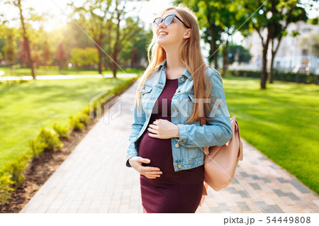 Beautiful pregnant girl student happily looking Beautiful pregnant girl student happily looking 54449808