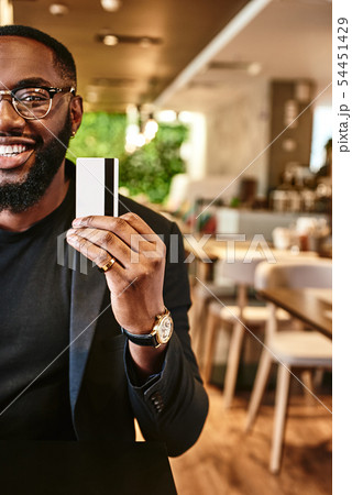 Price is what you pay. Value is what you get. Smiling african american businessman holds his credit Price is what you pay. Value is what you get. Smiling african american businessman holds his credit 54451429
