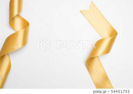 Gold ribbon in roll on white Gold ribbon in roll on white 54451753