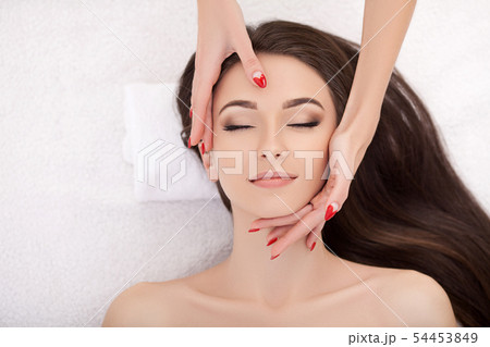 Woman under professional facial massage in beauty spa Woman under professional facial massage in beauty spa 54453849