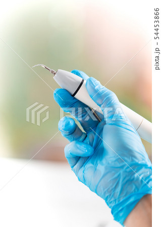 Visit the dental office. Dental treatment, modern instruction. Dentist hands in protective gloves Visit the dental office. Dental treatment, modern instruction. Dentist hands in protective gloves 54453866
