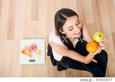 sporty woman with scale and green apple and orange sporty woman with scale and green apple and orange 54455677
