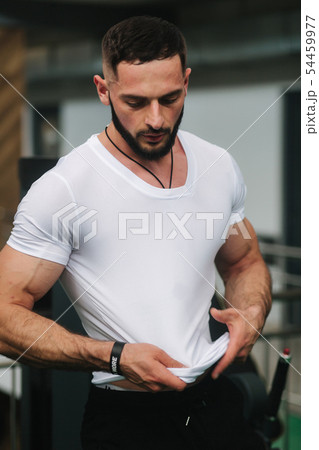 Young athlete posing with a torso for photography in gym. Bodybuilder, athlete with pumped muscles 54459977