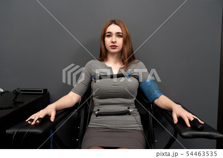 Woman sitting on chair during lie detector test 54463535