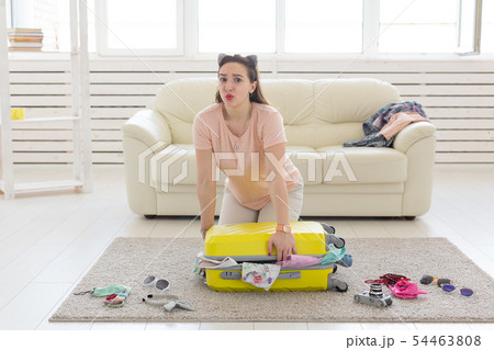 Vacation, journey and holidays concept - woman collecting clothes on the floor 54463808