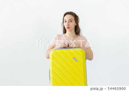 Trip, travel and holidays concept - woman with her yellow suitcase over white background Trip, travel and holidays concept - woman with her yellow suitcase over white background 54463900