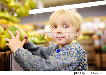 Cute toddler boy in a food store or a supermarket Cute toddler boy in a food store or a supermarket 54466625