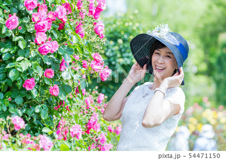 満開のバラ園 を楽しむミドル女性  薔薇のアーチ バラ 薔薇 花園 54471150