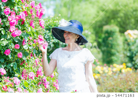 満開のバラ園 を楽しむミドル女性  薔薇のアーチ バラ 薔薇 花園 54471163