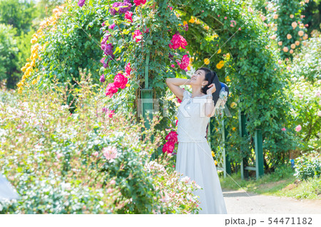 満開のバラ園 を楽しむミドル女性  薔薇のアーチ バラ 薔薇 花園 54471182