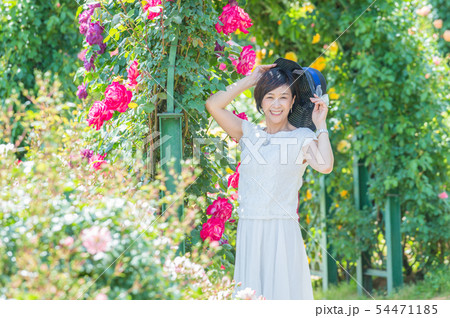 満開のバラ園 を楽しむミドル女性  薔薇のアーチ バラ 薔薇 花園 54471185