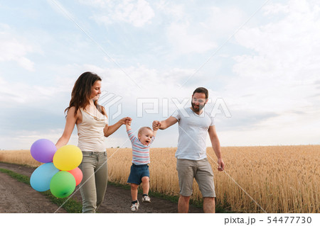 Happy family of mom, dad and son walking outdoors 54477730