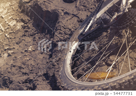 the Bicycle wheel is stuck in the mud. Close up 54477731