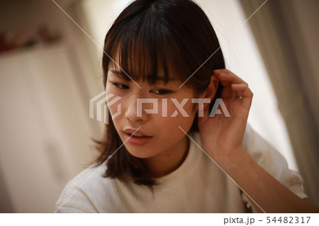 耳に違和感を感じる女性 54482317