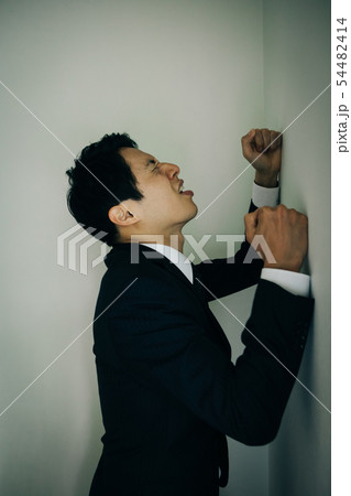 壁にぶつかるビジネスマン 日本人男性の写真素材