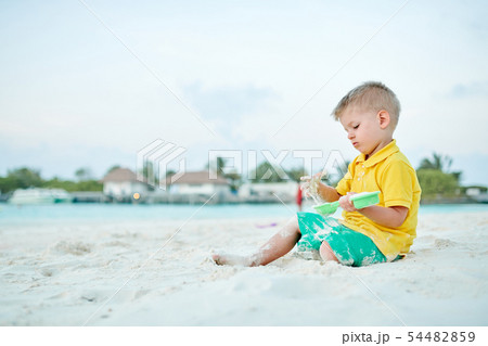 Three year old toddler playing on beach 54482859