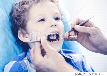Doctor and patient child. Boy having his teeth examined with dentist. Medicine, health care and 54483126