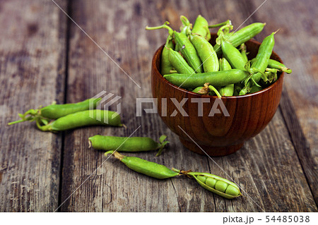 Green peas in a wooden bowl. Green peas in a wooden bowl. 54485038