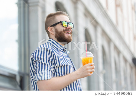 Side view of a pretty cheerful young businessman with a stylish mustache and a beard with juice in 54490065
