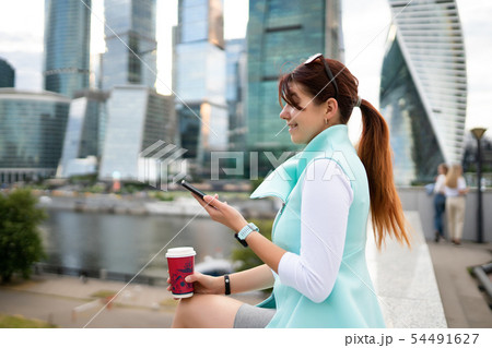 Portrait of business woman sitting with phone and cup of coffee 54491627
