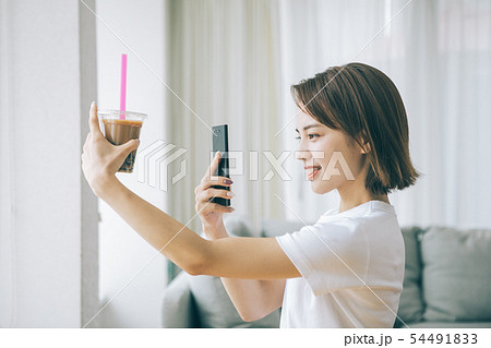 スマホでタピオカミルクティーを撮る若い女性 54491833