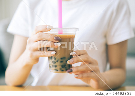 タピオカミルクティーを飲む若い女性 タピオカミルクティーを飲む若い女性 54492355