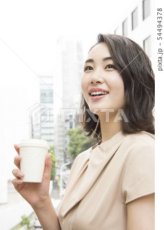 オフィスで飲み物を飲む女性の写真素材