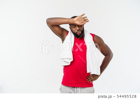 Close up shot of a sad tired African American man in sportswear wiping his face with a white towel Close up shot of a sad tired African American man in sportswear wiping his face with a white towel 54495528