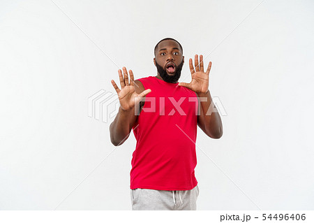 Young sport black man over an grey background very scared and afraid hidden Young sport black man over an grey background very scared and afraid hidden 54496406