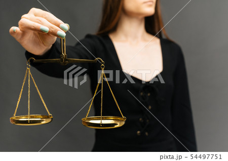 Serious woman holding the justice scale on dark Serious woman holding the justice scale on dark 54497751