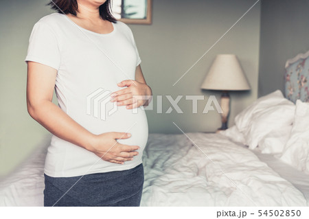 Happy pregnant woman and expecting baby at home. Happy pregnant woman and expecting baby at home. 54502850