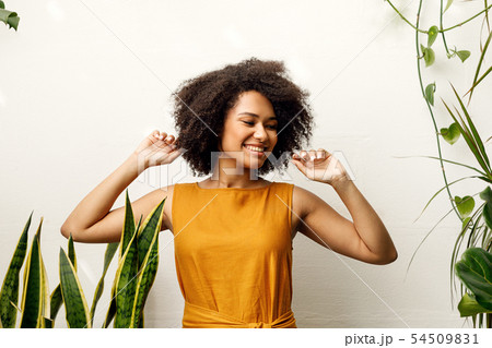 Happy woman posing in her floral shop at wall Happy woman posing in her floral shop at wall 54509831