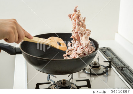 台所のキッチンでフライパンで豚肉を炒めている 台所のキッチンでフライパンで豚肉を炒めている 54510897