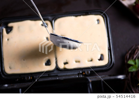 Waffles dough pouring on the baking machine Waffles dough pouring on the baking machine 54514416