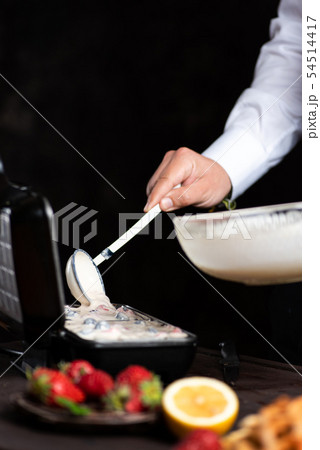 Chef pouring waffles dough on the baking machine Chef pouring waffles dough on the baking machine 54514417